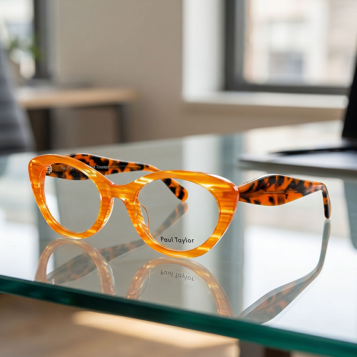 Full-body shot of TIGEZ glasses with vibrant colors on a glass surface in a contemporary office setting with natural light.